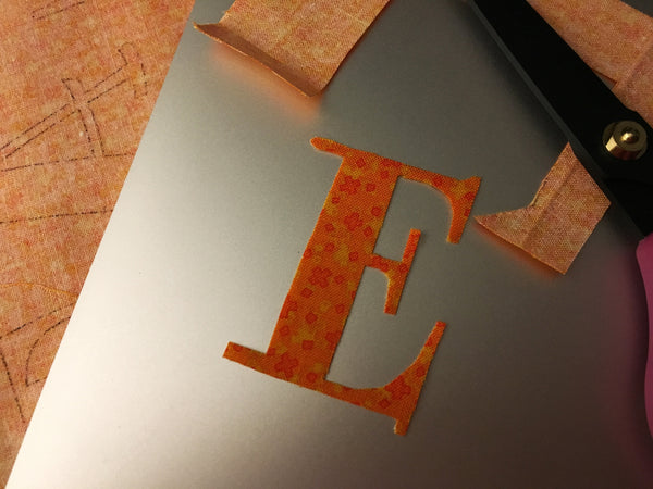 What you're seeing here is the letter that was cut out of Mistyfused fabric following the design that was perfectly transferred to the back of Mistyfused fabric by printing on Bunny Paper® then ironing Mistyfuse®d fabric on top of the printing. The Mistyfuse on the back of your fabric lifts the printed outline reversed perfectly for you. Easy, fast, mistake-proof.